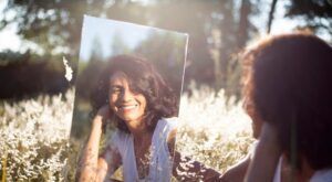 reflet dans un miroir d'une femme qui se sourit